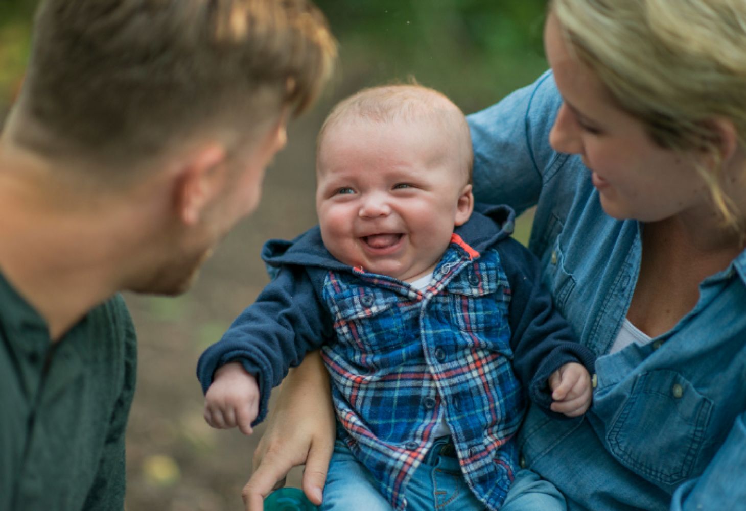 Baby smiling at man and woman