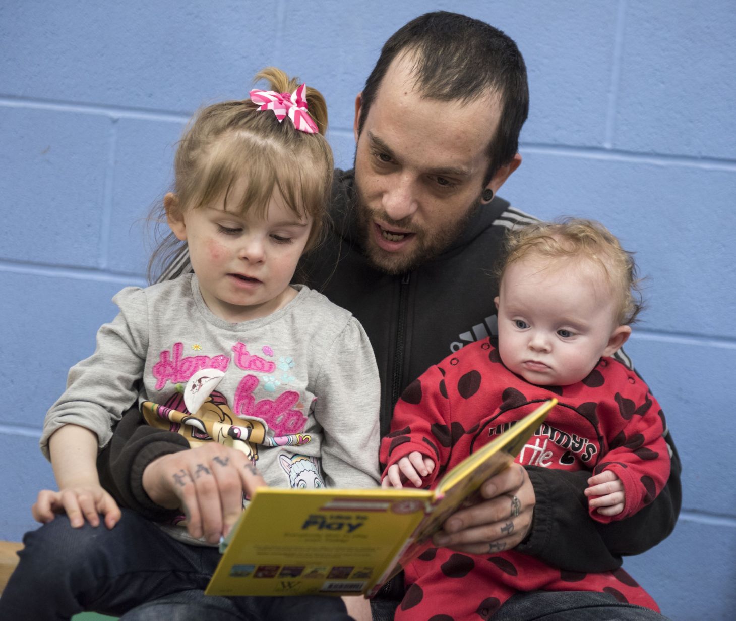Man reading with two children